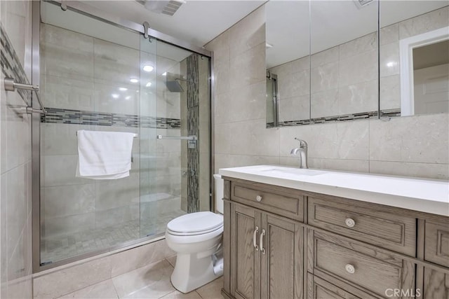 full bath with tile walls, tile patterned flooring, a stall shower, vanity, and toilet