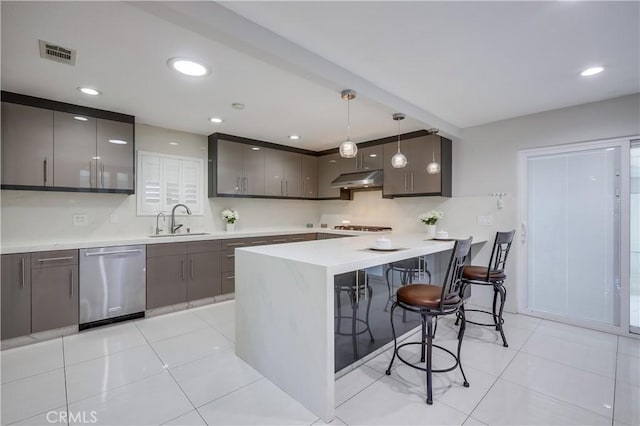 kitchen featuring a breakfast bar area, visible vents, dishwasher, a sink, and a peninsula