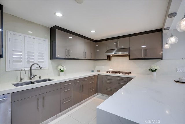 kitchen featuring a sink, gray cabinets, under cabinet range hood, and light countertops