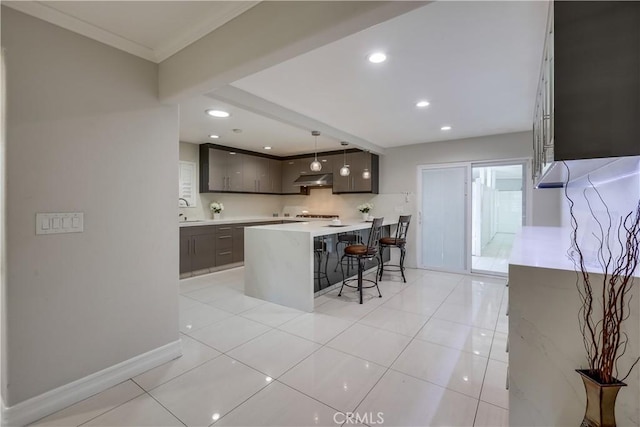 kitchen with a kitchen breakfast bar, modern cabinets, dark brown cabinets, light countertops, and a sink