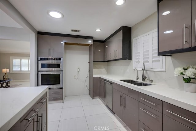 kitchen with a sink, light countertops, stainless steel appliances, and visible vents