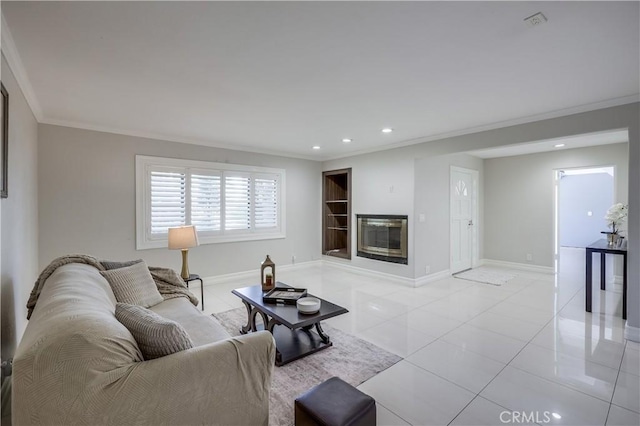 living room with baseboards, a glass covered fireplace, ornamental molding, recessed lighting, and light tile patterned flooring