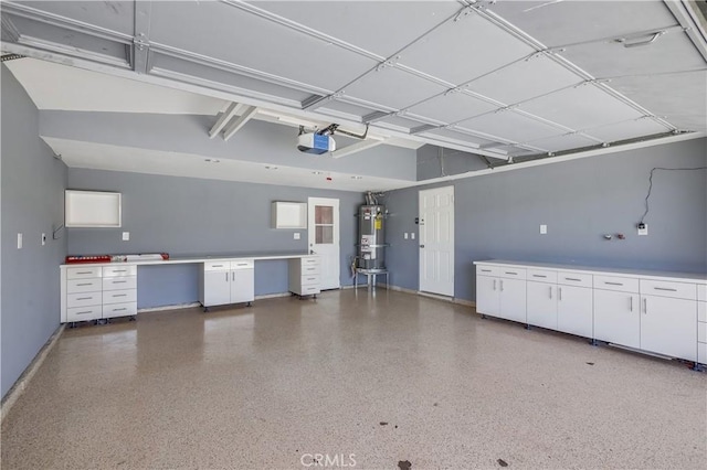 garage featuring baseboards, strapped water heater, and a garage door opener