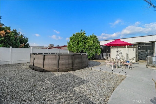 view of yard with a fenced in pool, a fenced backyard, and a patio area