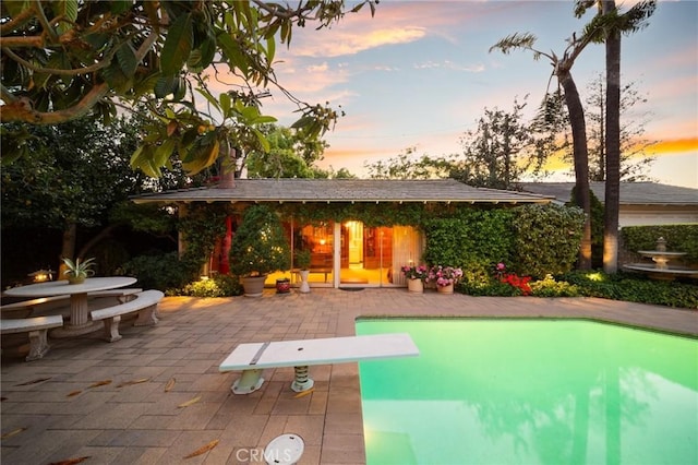 back of property at dusk with a patio area