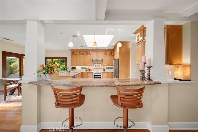 kitchen with freestanding refrigerator, range, beam ceiling, and tasteful backsplash