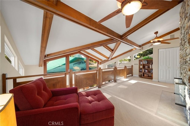 living room with carpet floors, plenty of natural light, ceiling fan, and beamed ceiling