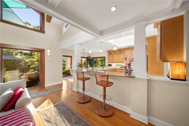 interior space featuring recessed lighting, baseboards, vaulted ceiling with beams, and light wood-type flooring
