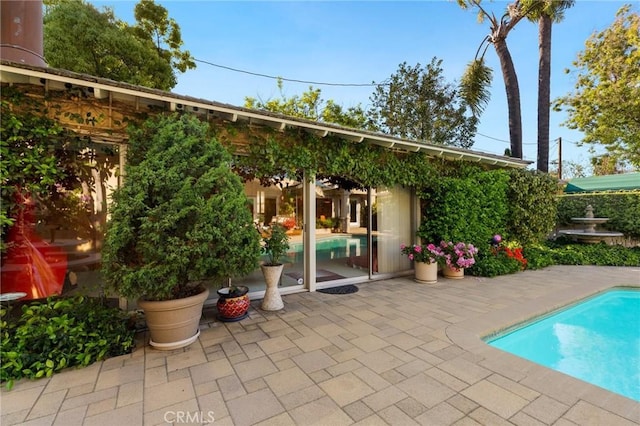 exterior space with a fenced in pool and a patio area