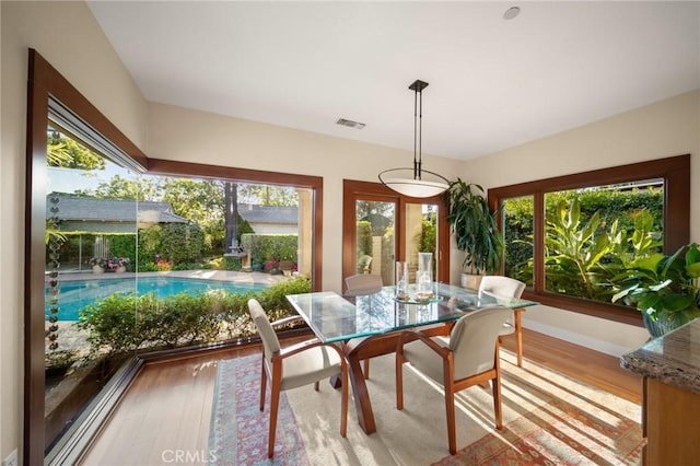 dining room featuring baseboards, wood finished floors, and visible vents