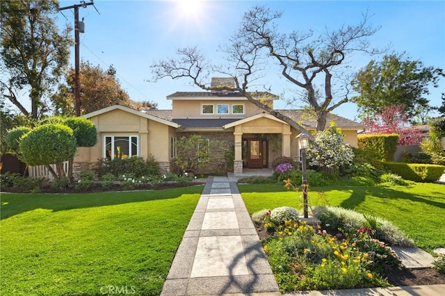 view of front of house with a front lawn, stucco siding, and stone siding