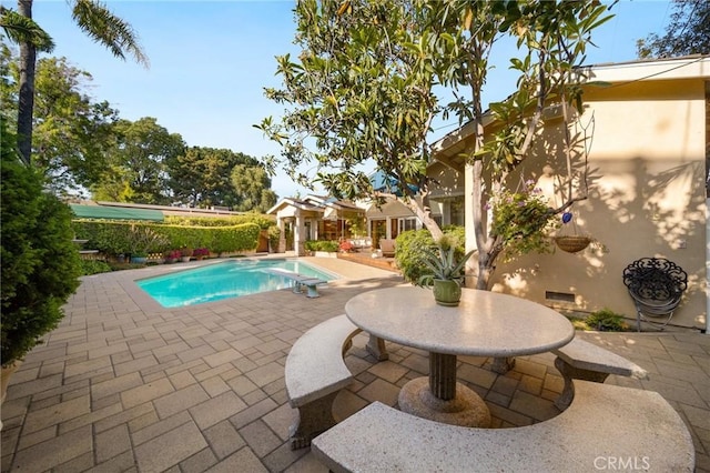 view of swimming pool with a diving board, a fenced in pool, and a patio area