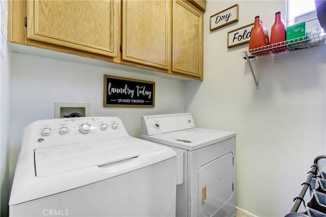 clothes washing area with cabinet space and separate washer and dryer