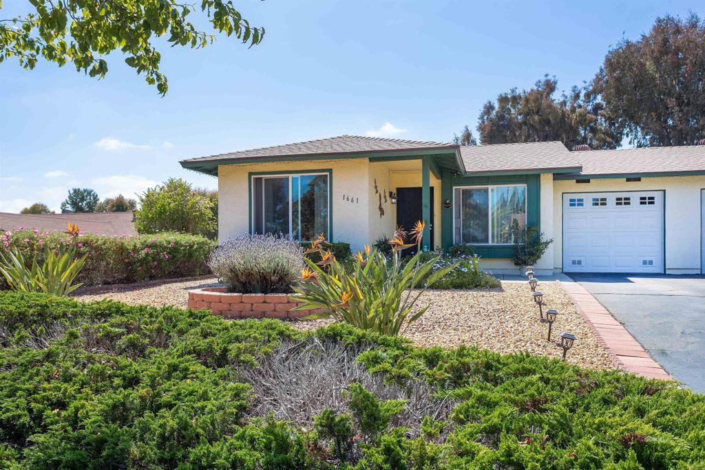 view of front of property featuring an attached garage, stucco siding, and driveway
