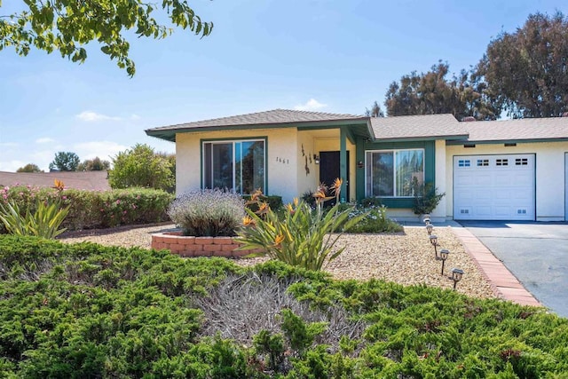 view of front of property featuring an attached garage, stucco siding, and driveway