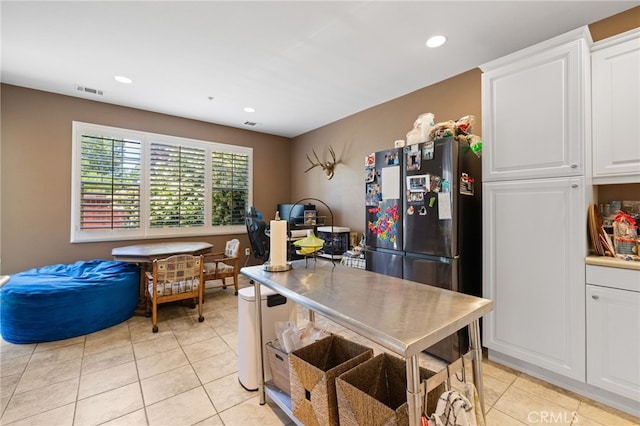 kitchen featuring light tile patterned floors, white cabinets, freestanding refrigerator, and recessed lighting