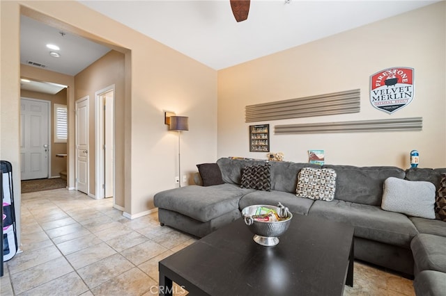 living room featuring a ceiling fan, baseboards, visible vents, and light tile patterned floors