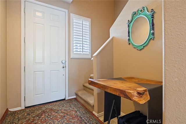 entrance foyer with baseboards and stairway
