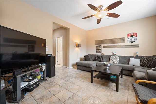 living area with ceiling fan and baseboards