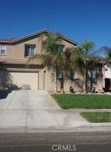 343 San Bernardino St, Los Banos, CA 93635 - view of front of home featuring driveway, an attached garage, stucco siding, a tiled roof, and a front lawn