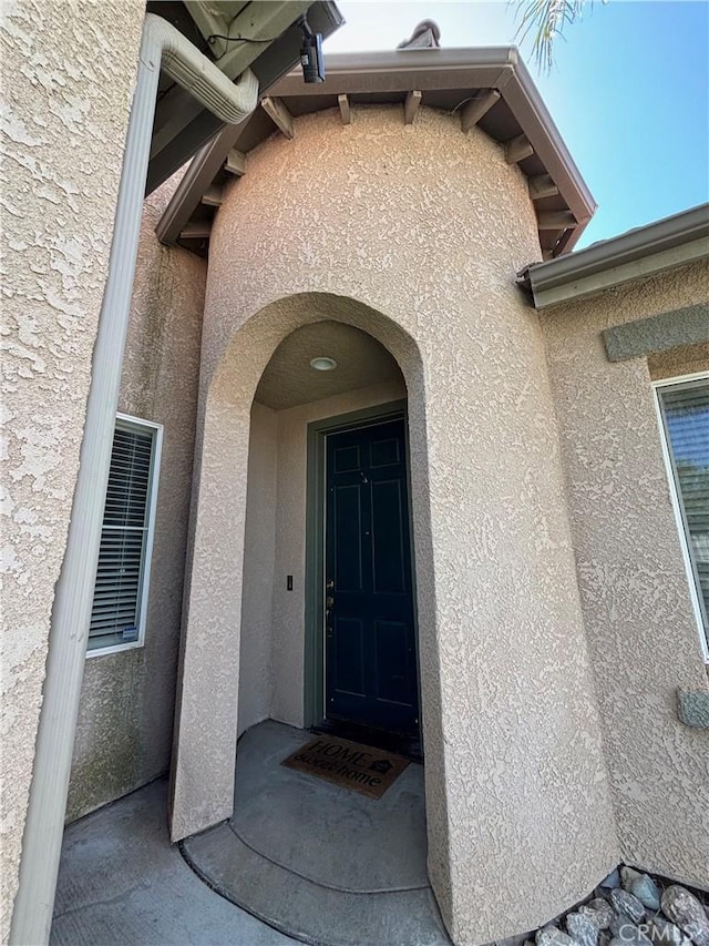 property entrance with stucco siding