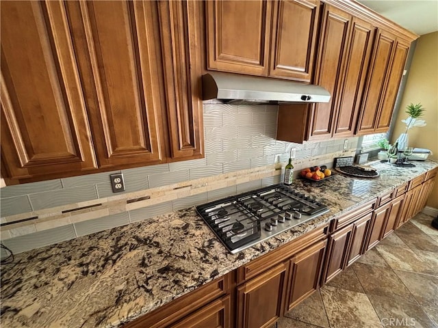 343 San Bernardino St, Los Banos, CA 93635 - kitchen with stainless steel gas cooktop, ventilation hood, stone counters, and brown cabinetry