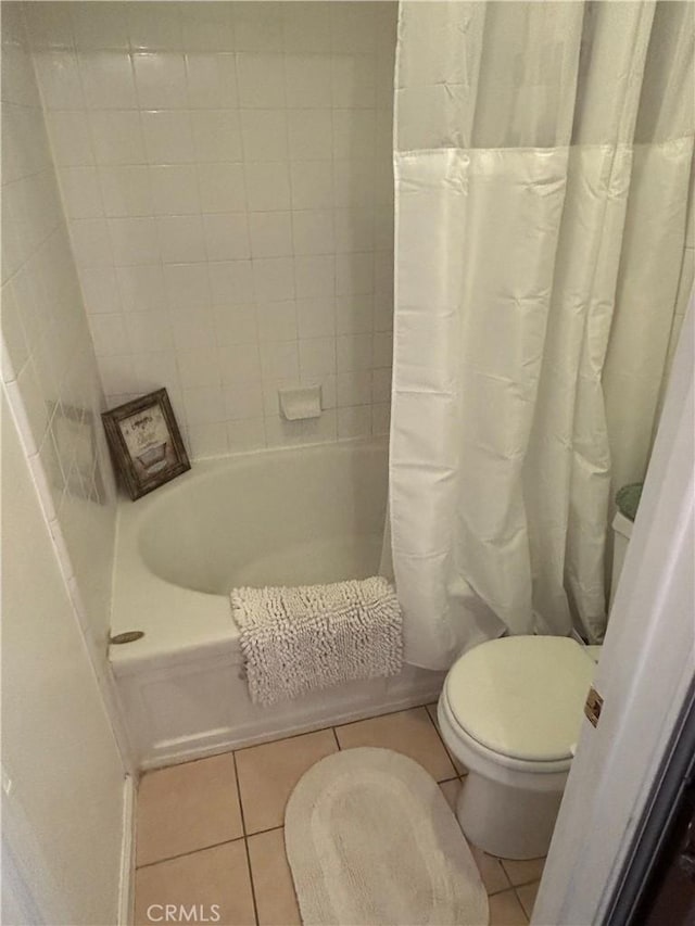 full bath with toilet, tile patterned floors, and shower / tub combo with curtain