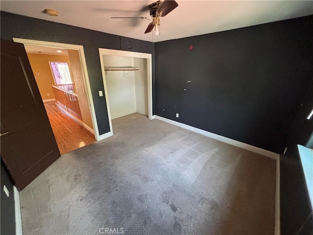 unfurnished bedroom with a closet, a ceiling fan, baseboards, and carpet floors