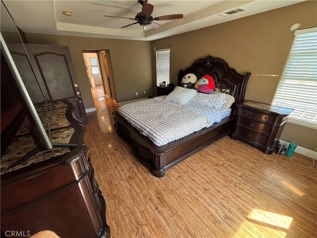 343 San Bernardino St, Los Banos, CA 93635 - bedroom featuring baseboards, a tray ceiling, light wood-style floors, and a ceiling fan