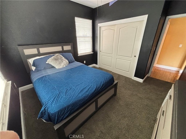 carpeted bedroom with baseboards and a closet