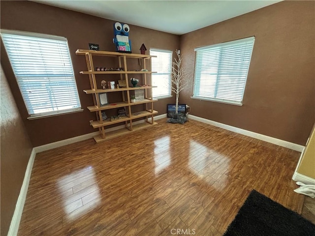 empty room with baseboards and wood finished floors