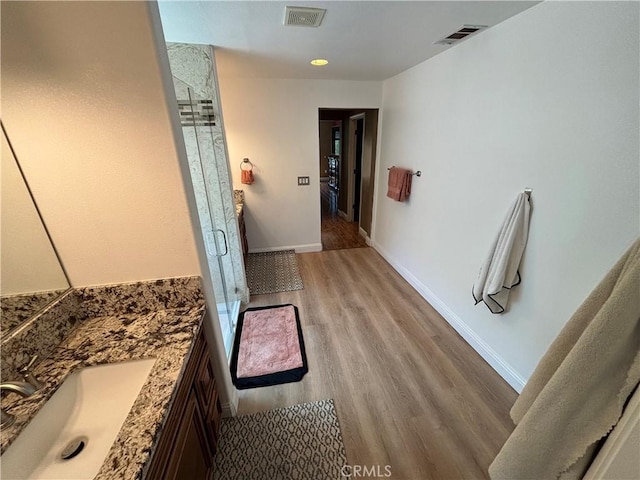 full bathroom with vanity, a stall shower, and visible vents