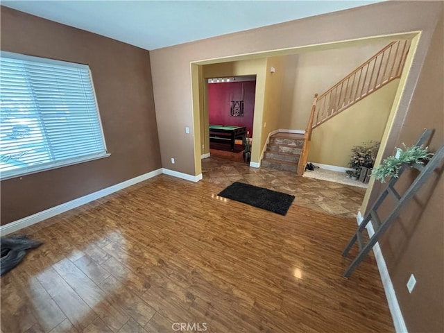 interior space featuring baseboards, stairs, and wood finished floors