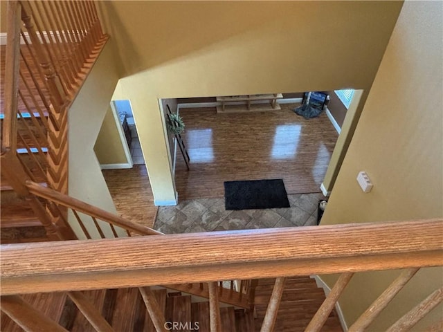 staircase with baseboards and wood finished floors