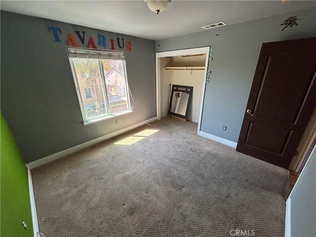 unfurnished bedroom with baseboards, carpet flooring, and visible vents