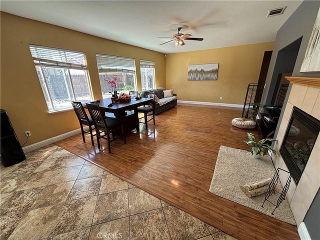343 San Bernardino St, Los Banos, CA 93635 - dining space featuring baseboards, a ceiling fan, and a tiled fireplace