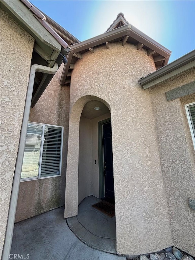 entrance to property featuring stucco siding