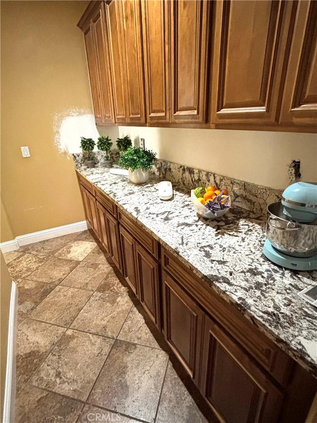 interior space with baseboards and light stone countertops
