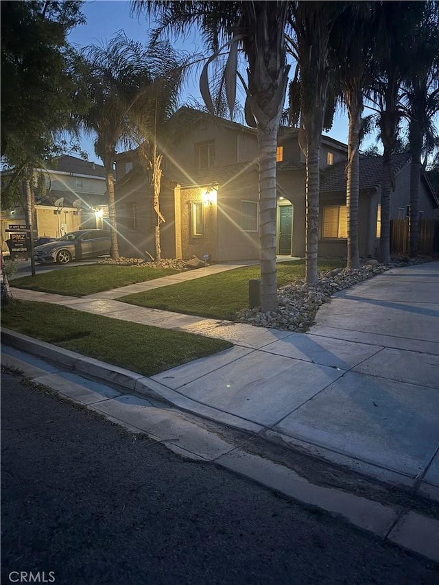 mediterranean / spanish home featuring stucco siding and a front yard