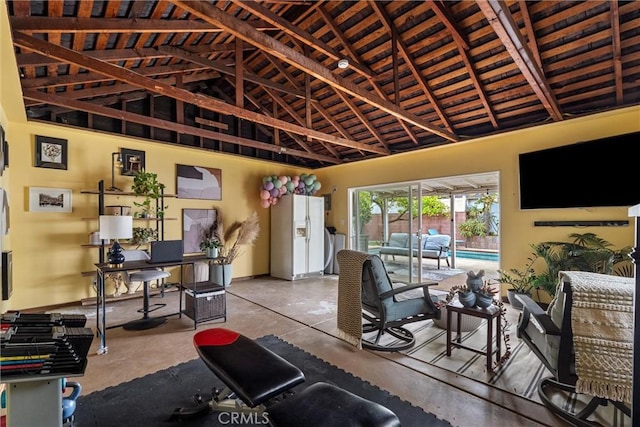 living room with concrete flooring and high vaulted ceiling