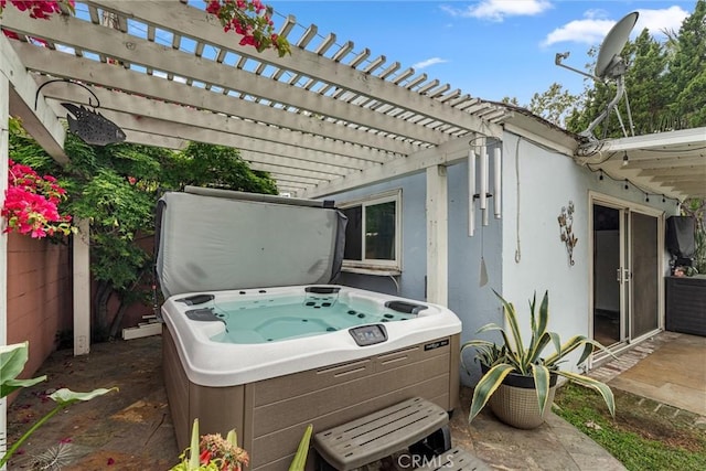 view of patio with a hot tub and a pergola