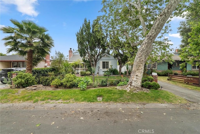 view of property hidden behind natural elements featuring fence private yard