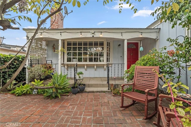 exterior space featuring covered porch and a chimney