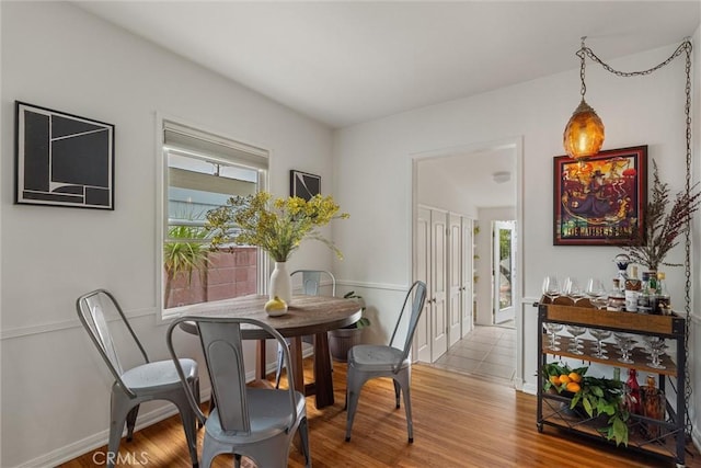 dining space featuring baseboards and wood finished floors
