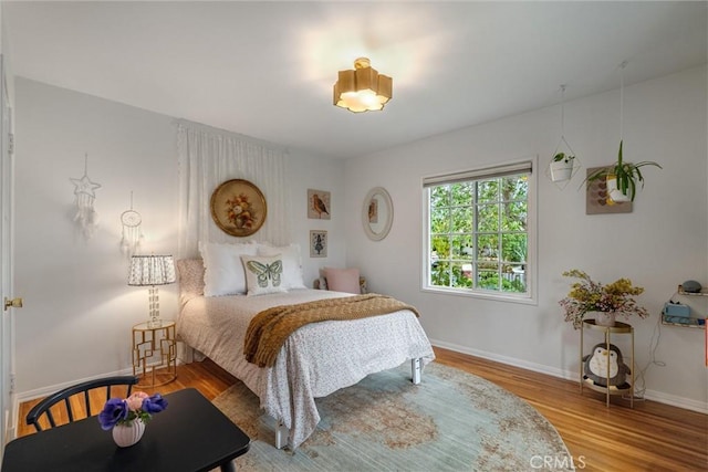 bedroom featuring baseboards and wood finished floors