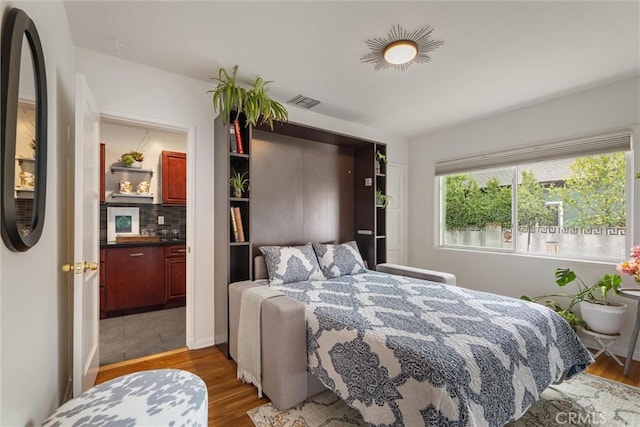 bedroom with visible vents and wood finished floors