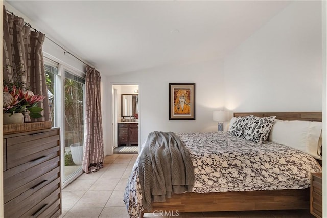 bedroom with light tile patterned floors, ensuite bath, and lofted ceiling