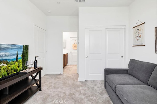 living room featuring baseboards, light carpet, and visible vents