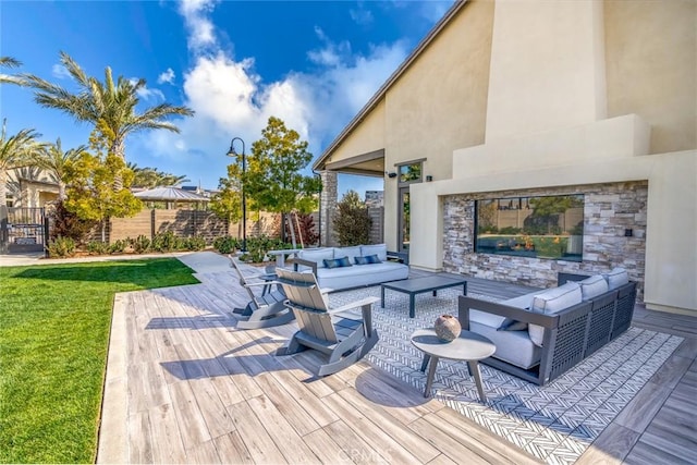 deck featuring an outdoor hangout area, fence, and a lawn