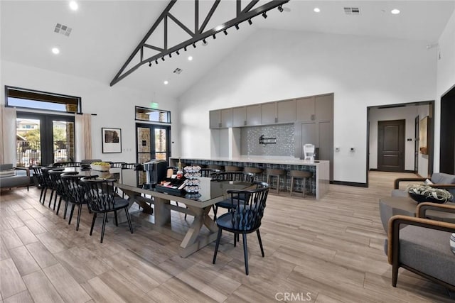 dining space with high vaulted ceiling, french doors, and visible vents